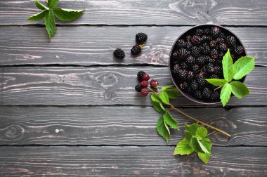 Kopya alanı karanlık bir rustik ahşap zemin üzerine bir kase taze böğürtlen. Berry, vitaminler, gıda arka plan