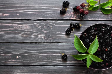 Kopya alanı karanlık bir rustik ahşap zemin üzerine bir kase taze böğürtlen. Berry, vitaminler, gıda arka plan