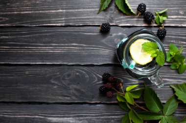 Böğürtlen, limon ve nane bir cam kavanoza kopya alanı üstten görünüm karanlık bir rustik ahşap zemin üzerine yaz içkiyle. Berry, vitaminler, gıda arka plan