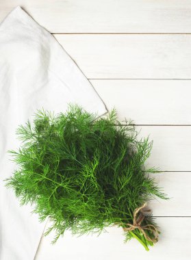 Taze dereotu bir kesim üzerinde bir bıçak ile Yönetim Kurulu ve dereotu bir ahşap masa üstü beyaz görünümde demet. Taze yeşillik, baharat, yemekler, sağlıklı bir yaşam tarzı pişirme süreci. Gıda arka plan