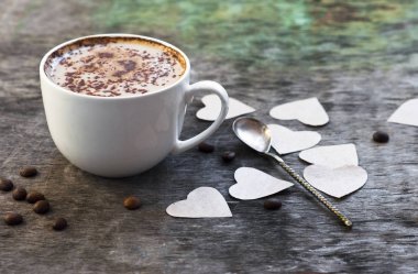 Bir fincan sıcak kahve ve orkide çiçek ahşap arka plan üzerinde. Geleneksel içki cappuccino veya kakao ahşap arka plan orkide çiçek sonbahar içki