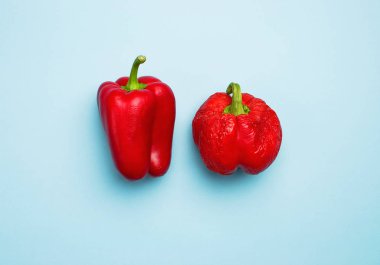 Taze kırmızı Bulgar biber ve buruşuk kurutulmuş biber. Taze biber, sağlık. Gıda yaratıcı kavramı. Üstten görünüm mavi arka plan düz koymak kopya alanı minimalist tarzı ile