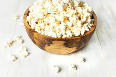 Kahverengi ahşap kase lezzetli geleneksel patlamış mısır hafif ahşap arka plan ile. Üstten görünüm bir hafif yemek arka plan. Mısır yemekleri