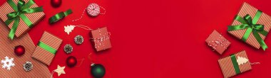 Hediye kutuları, Noel topları, oyuncaklar, çam kozalakları, kırmızı zemin üzerine şerit. Festival, kutlama, Xmas tatil 2019 tebrik kartı yeni yıl Noel hediyeleri. Düz yatıyordu, en iyi görünümü
