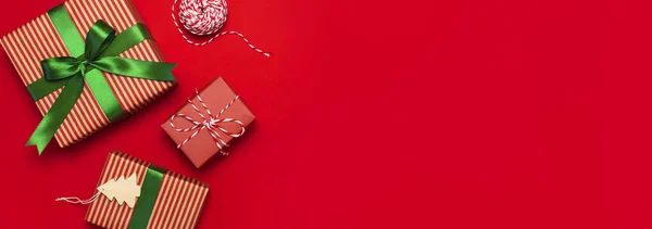 Hediye kutuları kırmızı arka plan en iyi görünüm düz yeşil şerit ile yatıyordu. Tatil kavramı, yeni yıl veya Noel hediye kutusu, Xmas tatil sunar. Tebrikler metin için yer arka plan.