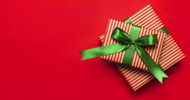Hediye kutuları kırmızı arka plan en iyi görünüm düz yeşil şerit ile yatıyordu. Tatil kavramı, yeni yıl veya Noel hediye kutusu, Xmas tatil sunar. Tebrikler metin için yer arka plan.