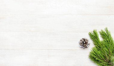 Noel arka plan, yeşil Çamın dalları, kar beyaz ahşap masa üzerinde süslenmiş koniler. Kenarlık ve kopya alanı tasarım en iyi görünümü ile yaratıcı kompozisyon. Yeni yıl, tatil, dekorasyon