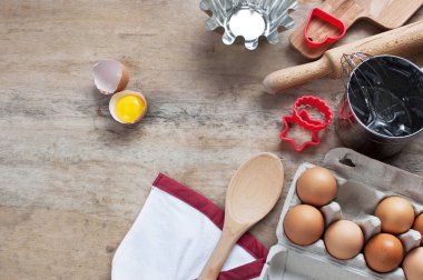 Mutfak ahşap bir masa üzerinde Metal mutfak eşyaları kaşık yumurta öğeleri. Yemek pişirme yumurta yiyecek üst görünüm mutfak eşyaları