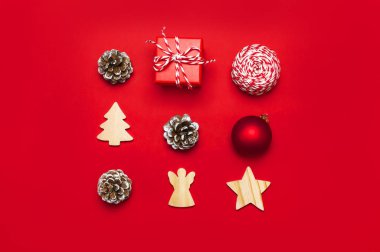 Noel kompozisyon. Yeni yıl ahşap oyuncak, çam kozalakları, kırmızı top, kar tanesi, Hediyelik sicim kırmızı arka plan düz üzerinde yatıyordu üstten görünüm kopya alanı. Noel Kış dekorasyon doğa yeni yıl kavramı