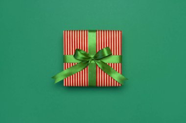 Hediye kutusu ile yeşil şerit yeşil arka plan en iyi görünüm düz üzerinde yatıyordu. Tatil kavramı, Doğum günü hediyesi, yılbaşı ya da Noel hediye kutusu Xmas tatil tebrikler arka plan metin için yer sunar.