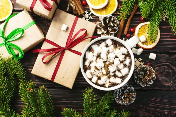 Чашка гарячої кави з зефіром, ялиновими гілками, шишками, різдвяними подарунками, чашками апельсина, сніжинками, корицею, новорічною різдвяною композицією. Традиційне святкове прикраса Різдвяний темний — стокове фото