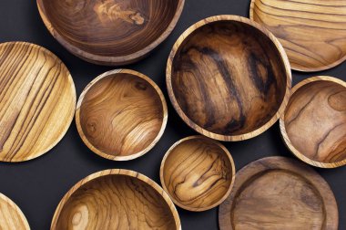 Mutfak, kase, siyah bir zemin üzerine plakalar için ahşap mutfak eşyaları. Doğal yemekler, sağlıklı bir yaşam tarzı kavramı.