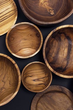 Mutfak, kase, siyah bir zemin üzerine plakalar için ahşap mutfak eşyaları. Doğal yemekler, sağlıklı bir yaşam tarzı kavramı.