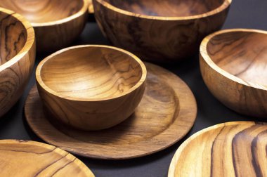 Mutfak, kase, siyah bir zemin üzerine plakalar için ahşap mutfak eşyaları. Doğal yemekler, sağlıklı bir yaşam tarzı kavramı. Ahşap ahşap Eko-ware doku