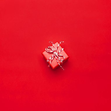 Bir kırmızı hediye kutu kırmızı arka plan en iyi görünüm düz dekoratif dantel ile yatıyordu. Xmas tatil tatil kavramı yeni yıl veya Noel hediye kutusu sunar. Tebrikler arka plan metin için yer ile