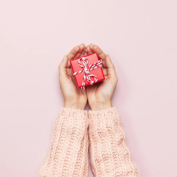 Frauenhände Rosafarbenem Strickpullover Mit Roter Geschenkschachtel Auf Rosa Hintergrund Flach — Stockfoto