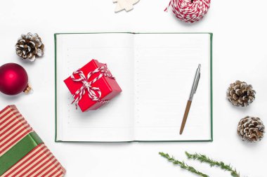 Açık defter ile boş sayfalar, hediye kutuları, beyaz arka plan düz dallarda köknar üstten görünüm yatıyordu. Noel planlama kavramı tatil dekorasyon 2019 gol. Yeni yıl, yılbaşı, kış dekorasyonu