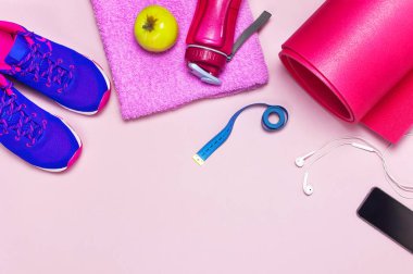Fitness kavramı ile Ultra mor pembe kadın spor ayakkabı, su şişesi, yoga mat, havlu, smartphone, kulaklık, pastel pembe arka plan düz elma üstten görünüm yatıyordu. Spor ayakkabı Fitness kavramı