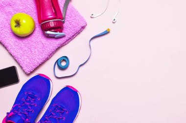 Fitness kavramı ile Ultra mor pembe kadın spor ayakkabı, su şişesi, havlu, smartphone, üstten görünüm kulaklık apple pastel pembe arka plan düz üzerinde yatıyordu. Spor Ayakkabı