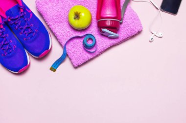 Fitness kavramı ile Ultra mor pembe kadın spor ayakkabı, su şişesi, havlu, smartphone, üstten görünüm kulaklık apple pastel pembe arka plan düz üzerinde yatıyordu. Spor Ayakkabı