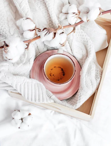 Pamuk ahşap tepsi dalı sıcak çay fincan beyaz keten ile yatakta kareli kazak ördü. Rahat sabah kahvaltı evde yaşam tarzı nazik kadın arka plan kopya alanı sonbahar kış kavramı