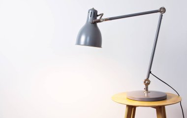 Gri masa lambası beyaz bir duvar karşı iç. İş veya eğitim metni için bir yer ile kavramı. İç mimari arka plan detay.