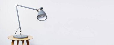 Gri masa lambası beyaz bir duvar karşı iç. İş veya eğitim metni için bir yer ile kavramı. İç mimari arka plan detay.