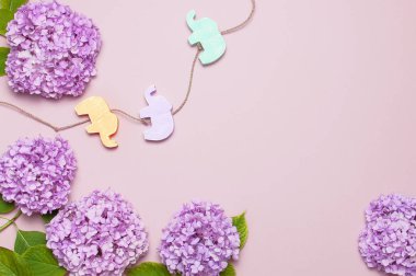 Lila Pembe ortanca çiçek ve çok renkli çocuk Ahşap oyuncaklar pastel pembe arka plan düz filleri şeklinde yatıyordu. Anneler günü, Doğum günü, Sevgililer günü, Bayan gün, kutlama kavramı.
