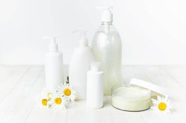 Plastik Konteyner krem, beyaz Kozmetik şişe kapsayıcılar ve beyaz bir arka plan üzerinde papatya çiçek açtı. Bitkisel Dermatoloji kozmetik hijyenik krem Spa konsept organik kozmetik doğal güzellik