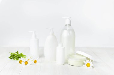 Plastik Konteyner krem, beyaz Kozmetik şişe kapsayıcılar ve beyaz bir arka plan üzerinde papatya çiçek açtı. Bitkisel Dermatoloji kozmetik hijyenik krem Spa konsept organik kozmetik doğal güzellik
