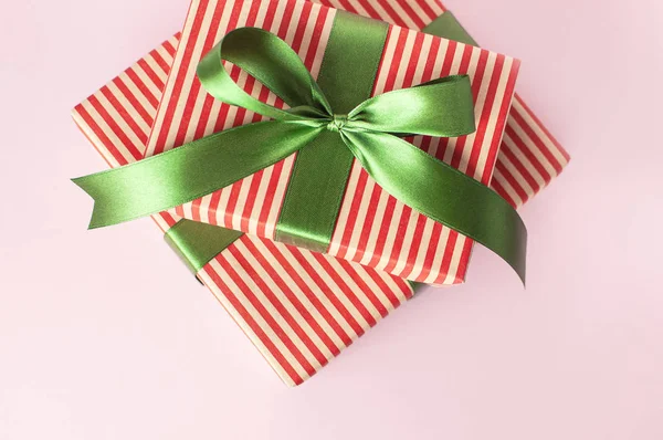 Gift boxes with green ribbon on pink background top view flat lay. Holiday concept, new year or Christmas gift box, presents Xmas holiday. Congratulations background with space for text. — Stock Photo, Image