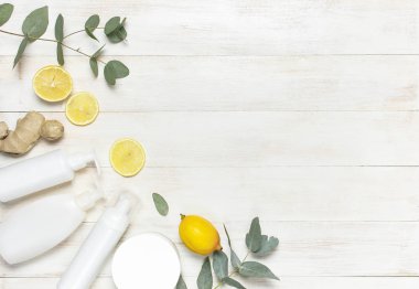 Beyazlar Kozmetik şişe kapsayıcılar, taze limon, zencefil kökü, okaliptüs Beyaz ahşap zemin üstüne düz yatıyordu kopya alanı görüntüleyin. Mock-up doğal güzellik ürün kavramı için boş etiket