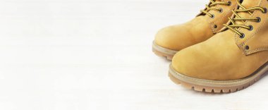 Yakın çekim sarı erkekler iş ahşap beyaz zemin üzerine doğal nubuk deri çizmeler. Modaya uygun rahat ayakkabı, gençlik tarzı. Reklam Sonbahar Kış ayakkabı, Satılık, dükkanı kavramı