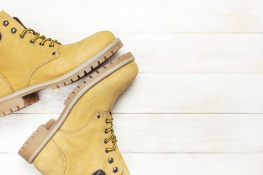 Doğal nubuk deri ahşap beyaz arka plan en iyi görünüm düz sarı erkekler iş çizmeler kopya alanı ile yatıyordu. Modaya uygun rahat ayakkabı, gençlik Sonbahar Kış ayakkabı satış dükkanı reklam kavramı stil.