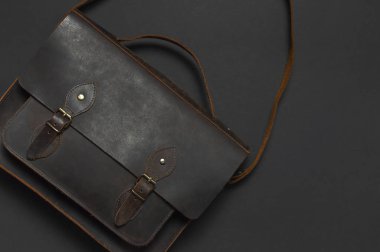 Moda kavramı. Kahverengi deri erkek çanta siyah arka plan en iyi görünüm düz üzerinde kopya alanı ile yatıyordu. İş, aksesuar işadamı, şık erkek iç giyim, iş geçmişi için evrak çantası