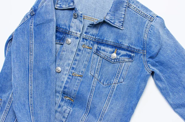 Close-up Blue denim jacket on isolated white background top view flat lay copy space. Denim, fashionable jacket, women\'s or men\'s trend clothing, fashion background