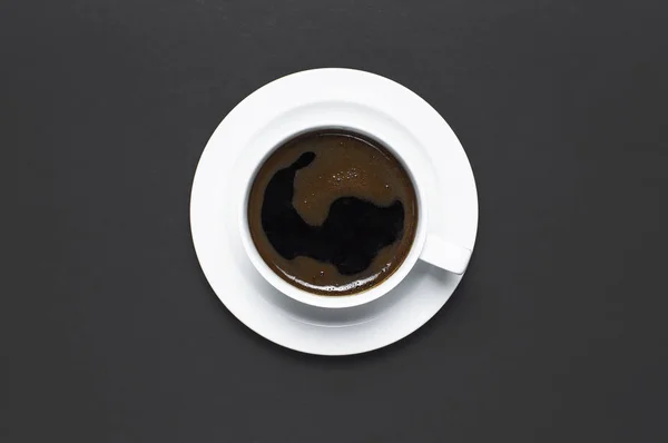 Flat lay cup of black coffee on gray dark background top view copy space. Minimalistic food concept, morning breakfast, time to work, hot drink coffee background