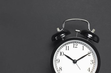 Gri koyu arka plan en iyi görünüm düz siyah retro çalar saat kopya alanı yatıyordu. Minimalist arka plan, zaman, son tarih, çalışmak için zaman, sabah kavramı