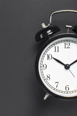 Gri koyu arka plan en iyi görünüm düz siyah retro çalar saat kopya alanı yatıyordu. Minimalist arka plan, zaman, son tarih, çalışmak için zaman, sabah kavramı