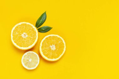 Olgun sulu limon, portakal ve yeşil yaprakları parlak sarı arka plan üzerinde. Limon meyve, narenciye en az kavramı, vitamin C. yaratıcı yaz minimalist arka plan. Düz yatıyordu, en iyi görünüm, kopya alanı