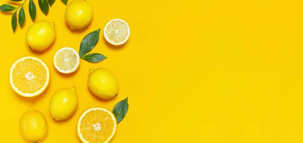 Olgun sulu limon, portakal ve yeşil yaprakları parlak sarı arka plan üzerinde. Limon meyve, narenciye en az kavramı, vitamin C. yaratıcı yaz minimalist arka plan. Düz yatıyordu, en iyi görünüm, kopya alanı