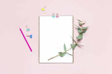 Düz yatıyordu Pano boş kağıt, renkli kalemler, klipler, okaliptüs dalları üzerinde pembe bir arka plan ile. Üstten görünüm kadın ofis çalışma alanı en az sahte kadar şablon kavramı kopya alanı kadınsı çiçek Masaüstü.