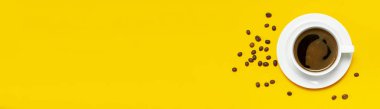 Düz yatıyordu fincan sade kahve ve kahve çekirdekleri üstünde sarı arka plan üstten görünüm Kopyala yer. Minimalist gıda kavramı, sabah kahvaltı, saat çalışma, sıcak içecek, kahve arka plan.