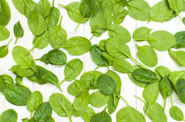 Taze yeşil ıspanak üzerinde beyaz ahşap rustik arka plan üstten görünüm kopya alanı bırakır. Bebek Genç ıspanak yaprakları, salata, sağlıklı gıda, diyet için madde. Beslenme kavramı