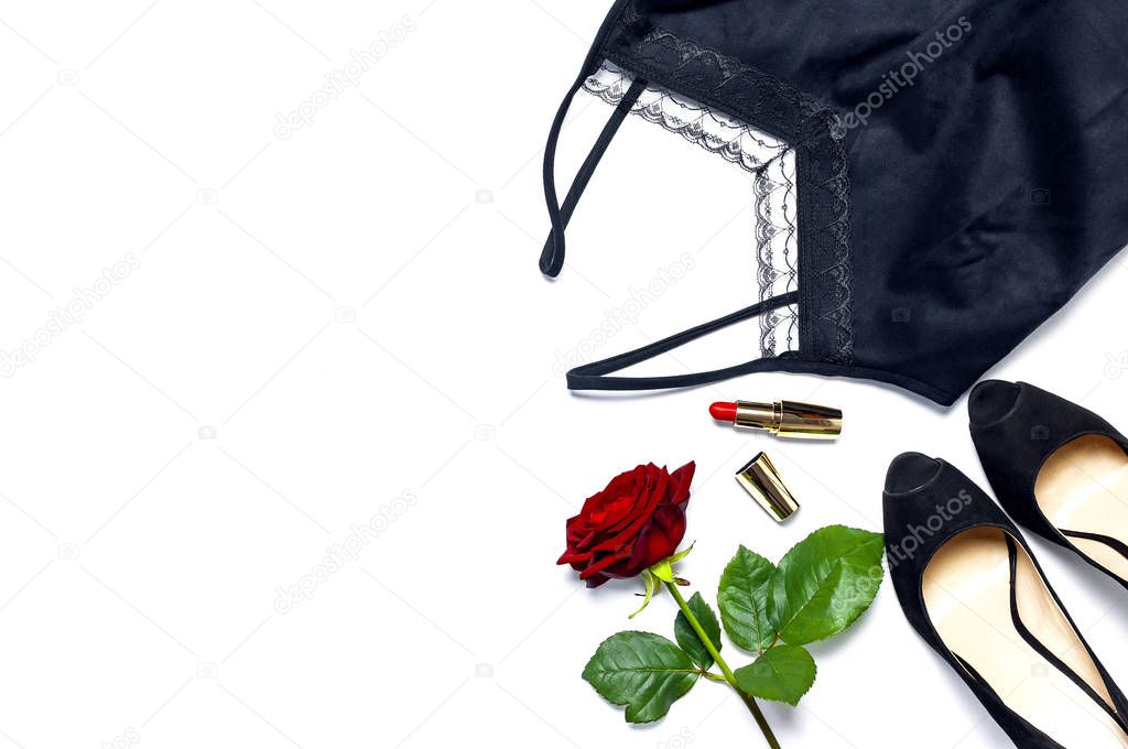 Female black T-shirt jacket with lace, classic shoes, red lipstick and rose flowers on white background top view flat lay. Beauty fashion background. Sexy clothes, fashion look, women's holiday