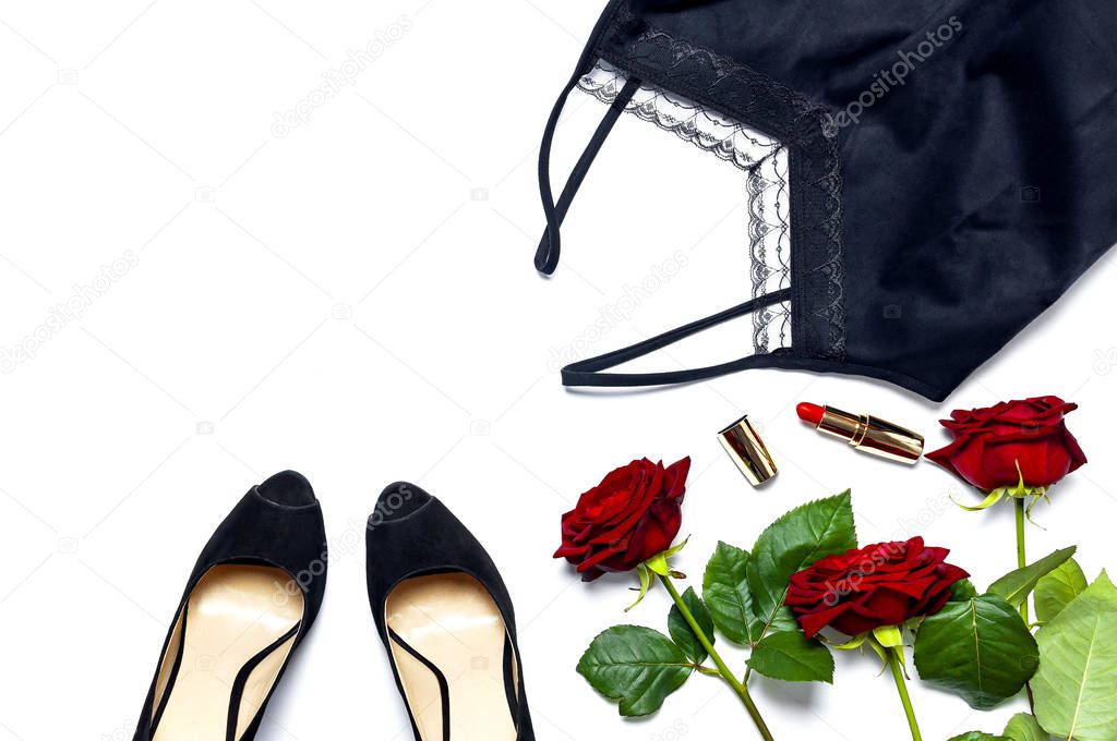 Female black T-shirt jacket with lace, classic shoes, red lipstick and rose flowers on white background top view flat lay. Beauty fashion background. Sexy clothes, fashion look, women's holiday