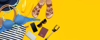 Kadın yaz Giyim Aksesuarları Sarı zemin üzerine. Seyahat tatil deniz kavramı. Şapka takım elbise kot şort deri sandalet güneş gözlüğü güneş deniz çanta pasaport telefon yüzme. Düz yatıyordu Üstten Görünüm