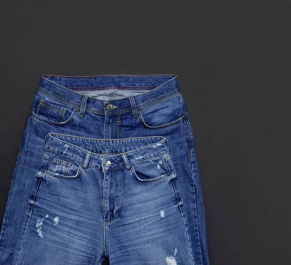 Zestaw dla mężczyzn i kobiet niebieskie dżinsy na czarnym tle płaski widok z góry określić. Wszystko ładne niebieskie dżinsy. Tło tekstura lub denim Jeans. Trend, odzież. Uroda i moda, odzież koncepcja. — Zdjęcie stockowe