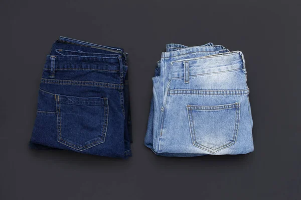 Стек різних блакитних джинсів на чорному тлі зверху вигляд плоский лежав. Краса і мода, концепція одягу. Деталь гарних блакитних джинсів. Джинсова текстура або джинсовий фон. Колекція джинсів . — стокове фото