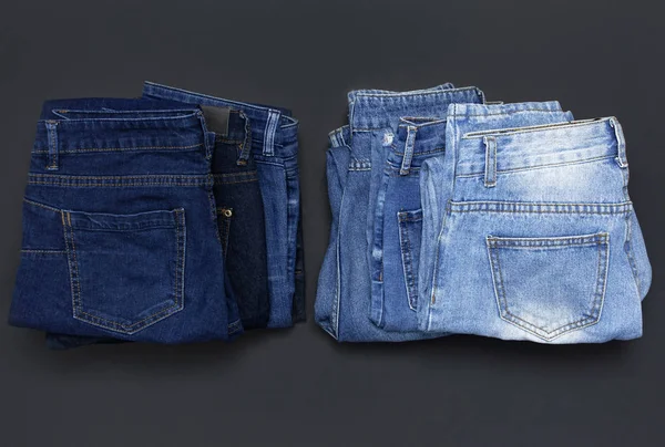 Стек різних блакитних джинсів на чорному тлі зверху вигляд плоский лежав. Краса і мода, концепція одягу. Деталь гарних блакитних джинсів. Джинсова текстура або джинсовий фон. Колекція джинсів . — стокове фото